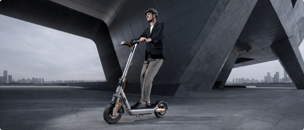 Mann fährt E-Scooter unter einer Brücke in der Stadt