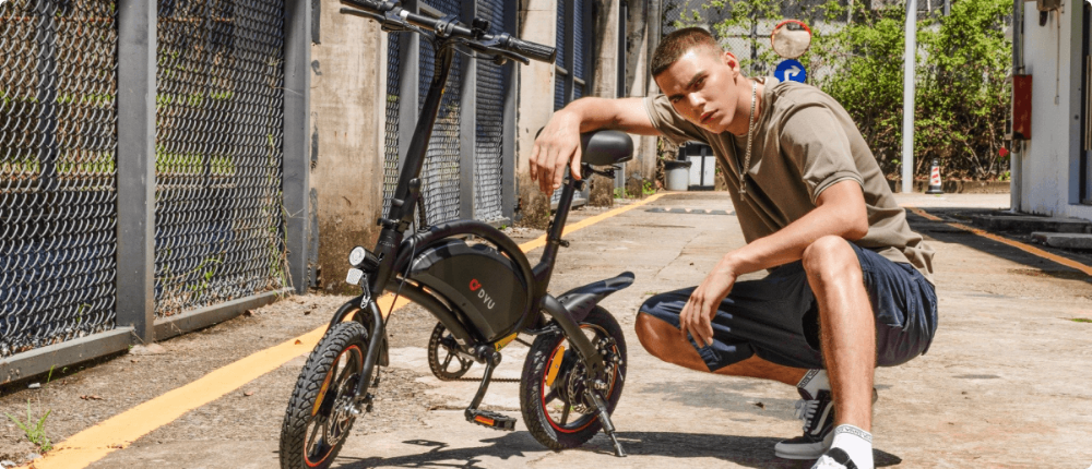 Mann sitzt mit zusammengeklapptem E-Scooter auf Treppenstufen