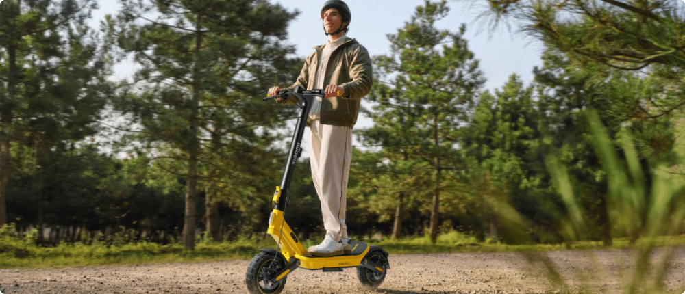 Mann hält gelben Xiaomi E-Scooter im Freien